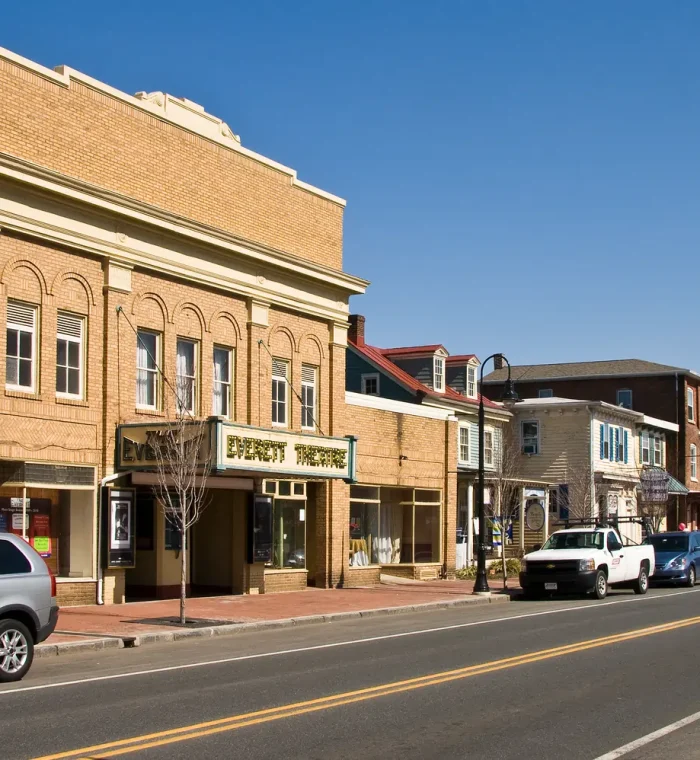 Historic Everett Theatre building in Middletown, DE, with surrounding shops and parked vehicles, showcasing the town's community atmosphere and local businesses.
