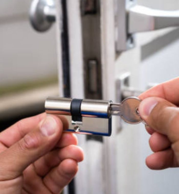 Person inserting a key into a door lock, highlighting commercial lockout services by Nova Locksmith.