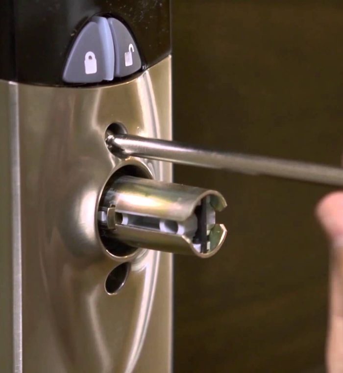 Close-up of a locksmith using a screwdriver to repair a door lock, highlighting tools and components relevant for 24/7 mobile locksmith services in Wilmington, DE.