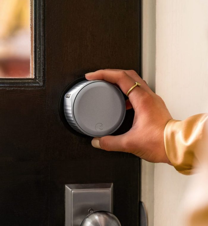 Hand turning a smart lock on a wooden door, illustrating home access solutions for lockout services in Wilmington, DE.